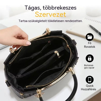 Női válltáska V-alakú varrással, arany szerelékekkel, több rekesszel és felső fogantyúval.